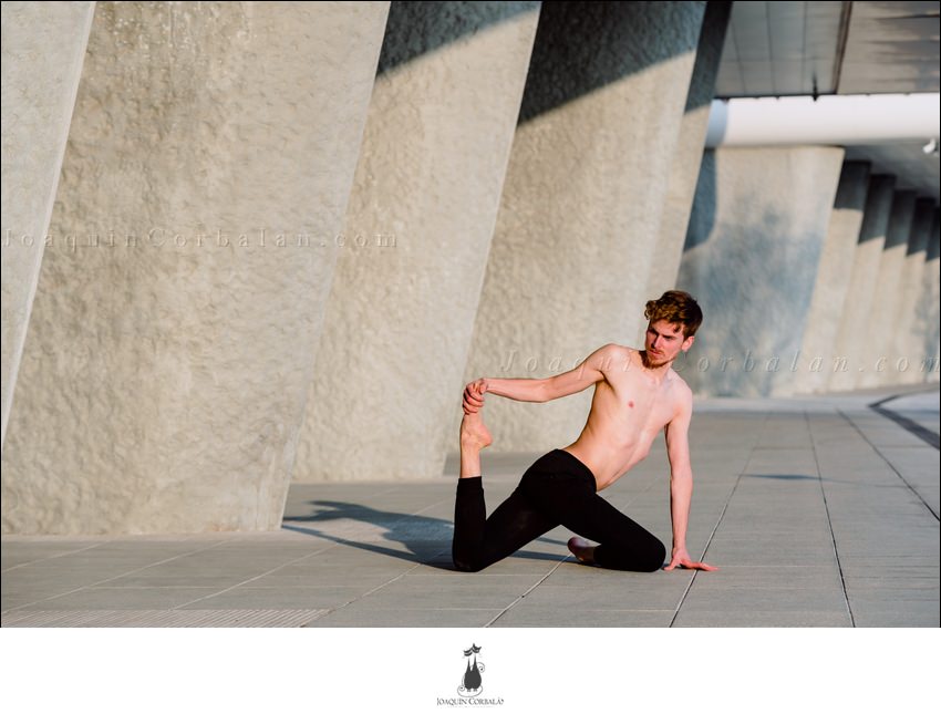 Young Male Runner Performing Leg Stretches Outdoors To Gain Flexibility.